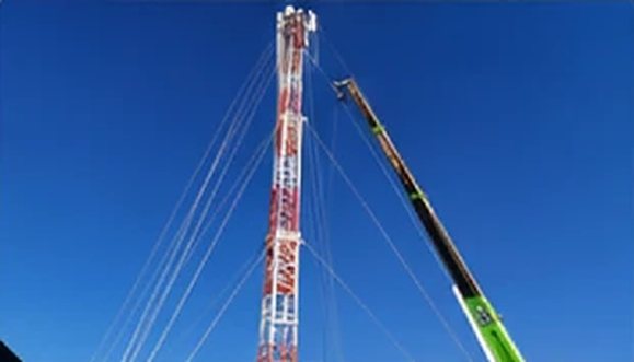 Crane raising a cell-on-wheels mast
